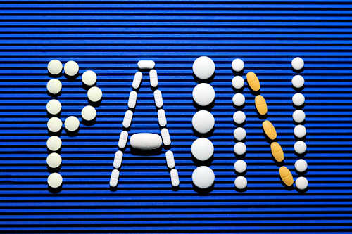 Word pain written using yellow and white tablets Word pain written using yellow and white tablets